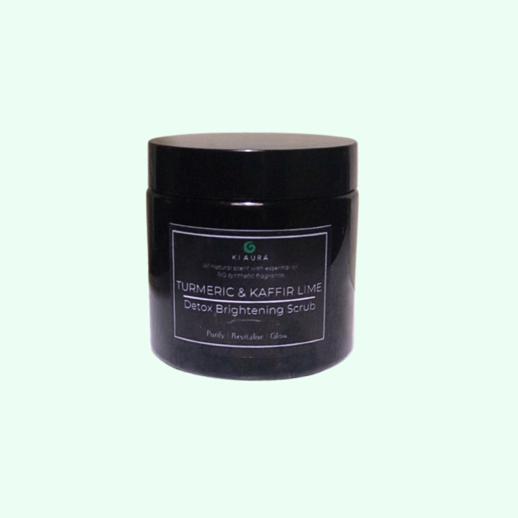 Black jar of Turmeric & Kaffir Lime Detox Brightening Scrub on a light gray background