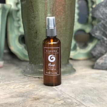 Brown spray bottle with a label on a wooden surface with a blurred natural background