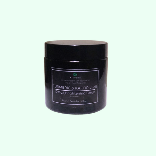 Black jar of Turmeric & Kaffir Lime Detox Brightening Scrub on a light gray background